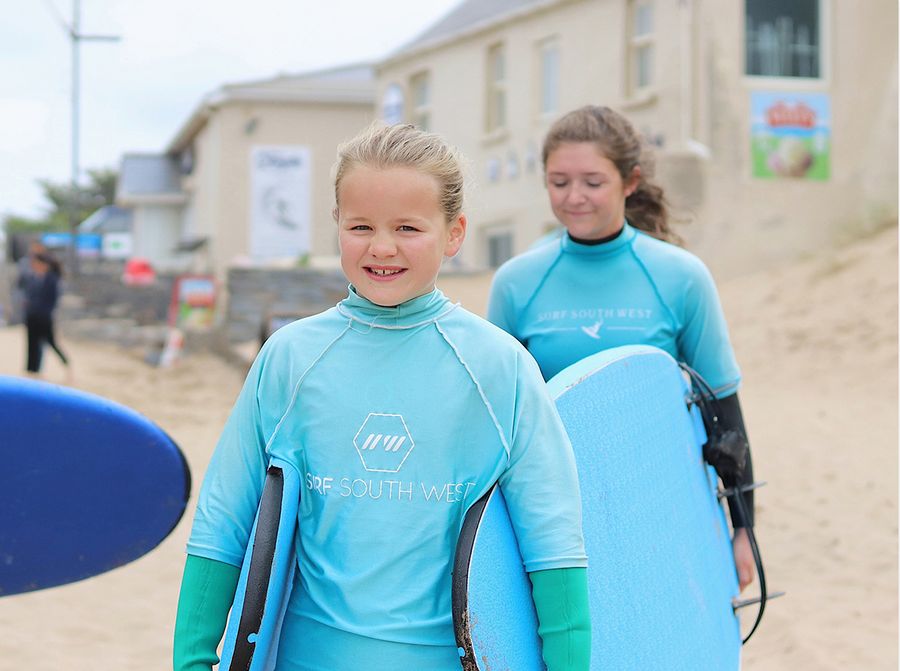 girls at beach with surf board