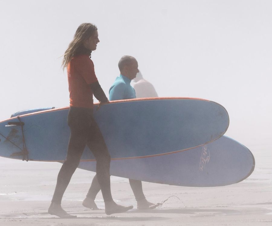 people at beach with surf board