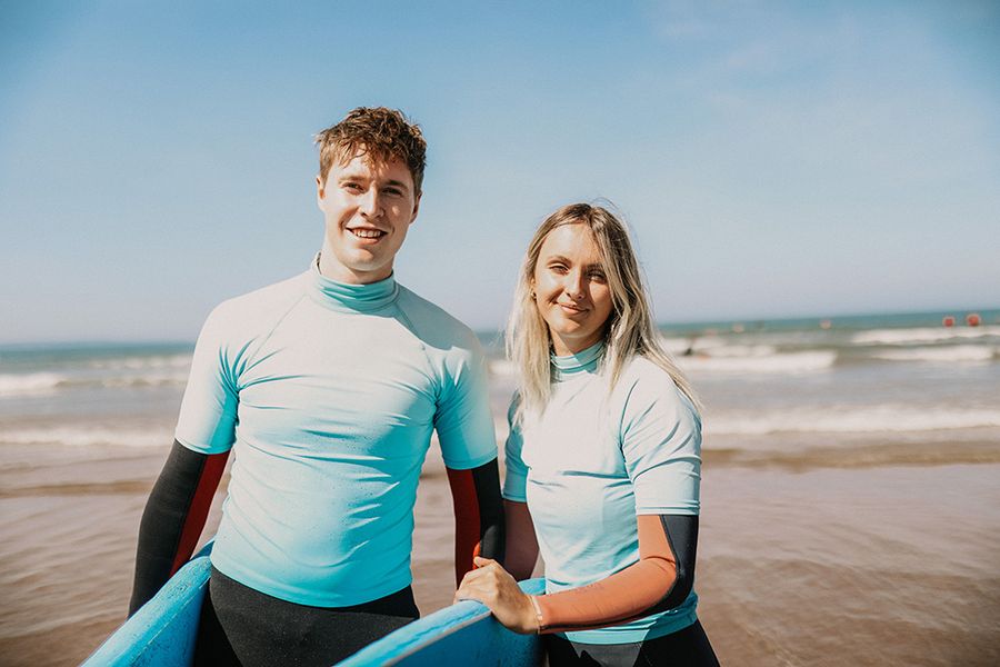 people holding surfboards on the beach
